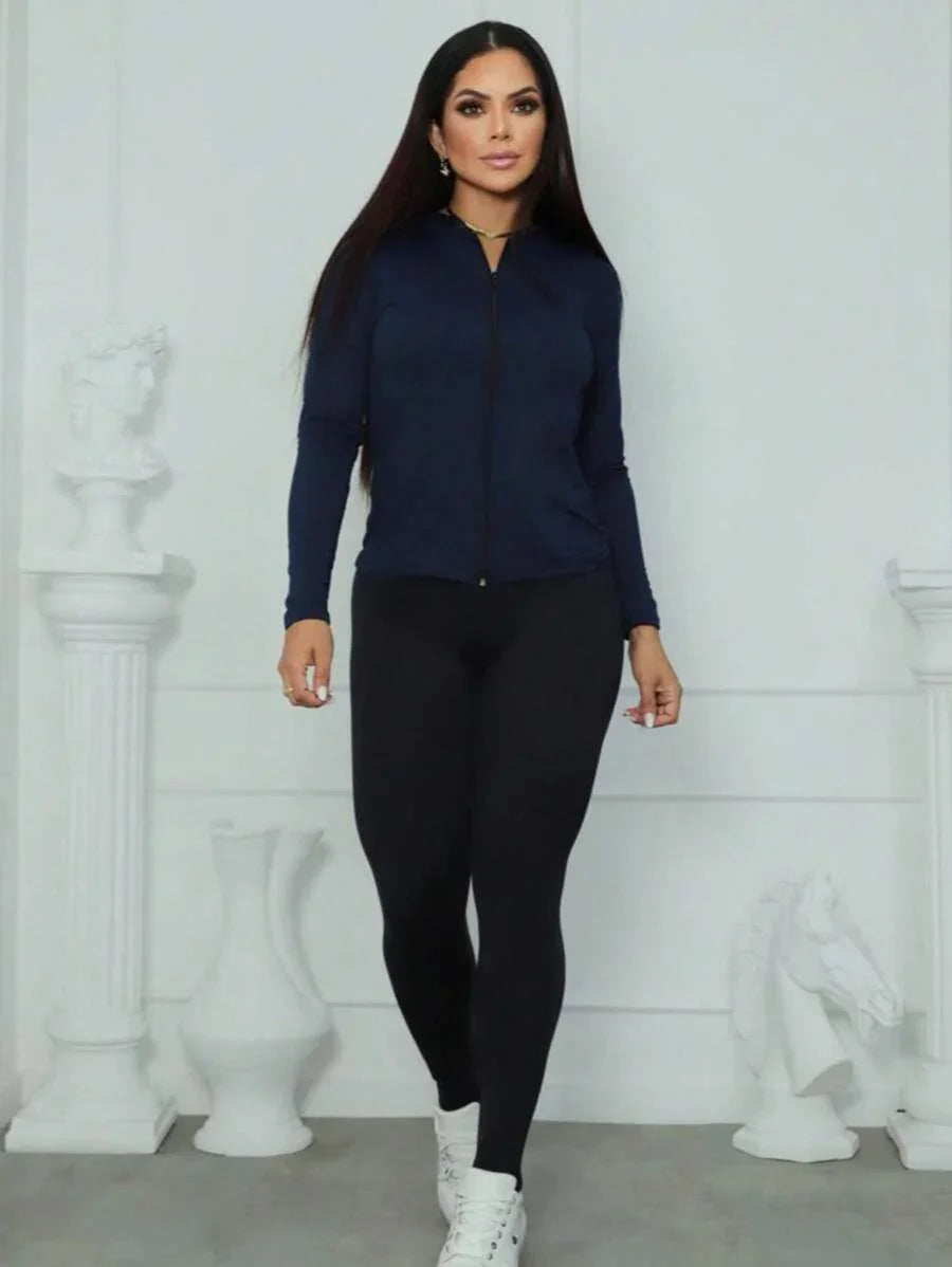 Mulher usando casaco azul marinho e legging preta em fundo branco fosco com esculturas brancas