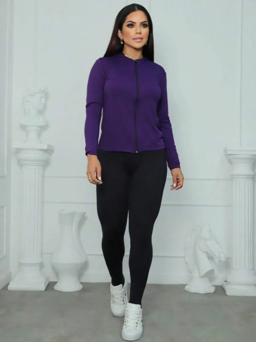 mulher vestindo casaco roxo e calça preta com tênis branco em fundo branco fosco com decoração clássica