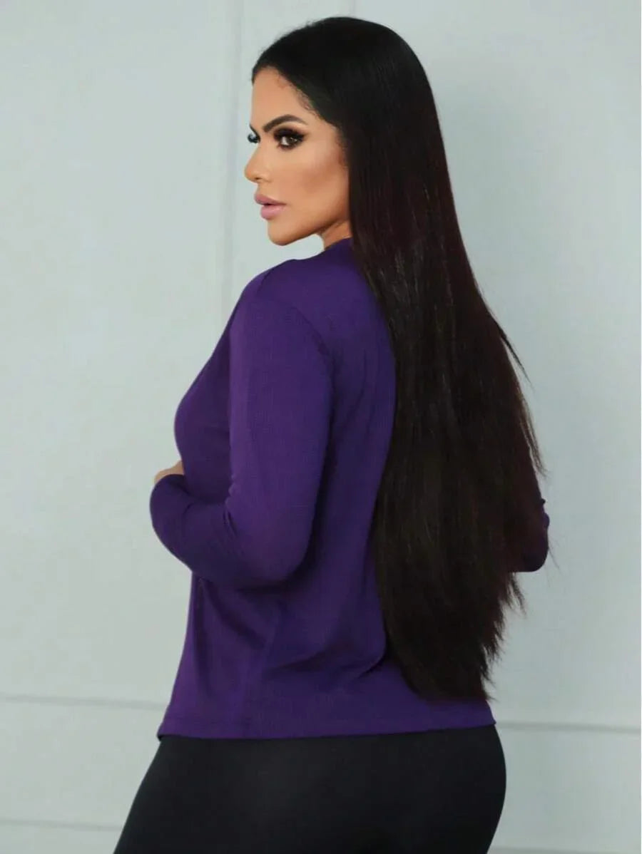 Mulher de cabelos longos vestindo casaco roxo em fundo branco fosco