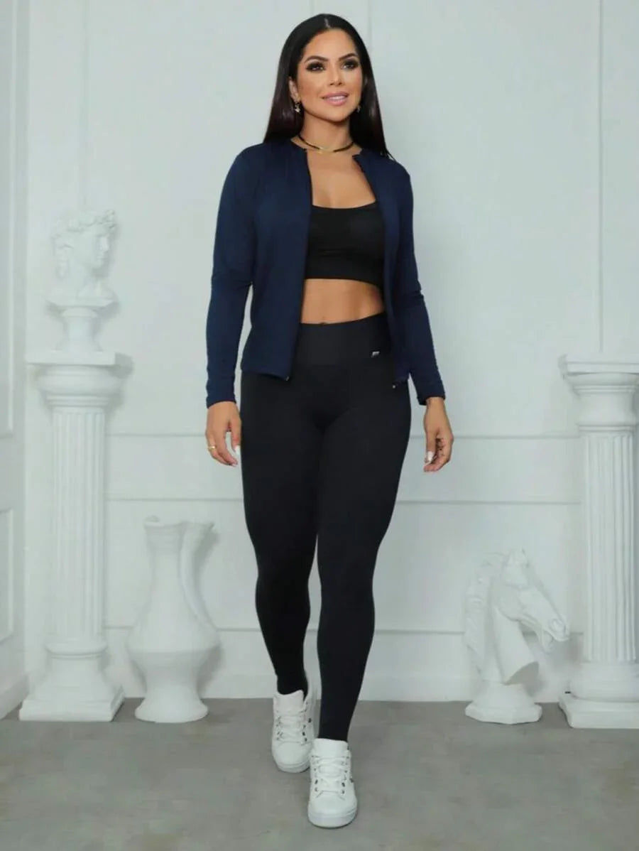 Mulher vestindo casaco azul marinho, top preto e calça legging preta em fundo branco fosco com esculturas brancas